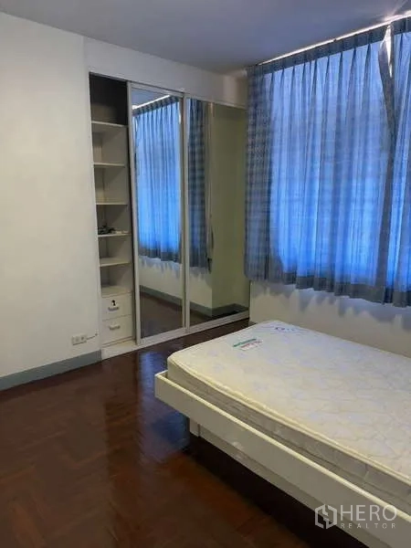 Detached House for rent in Bang Kapi, Bangkok - Bedroom with single bed and mirrored wardrobe with side shelving.