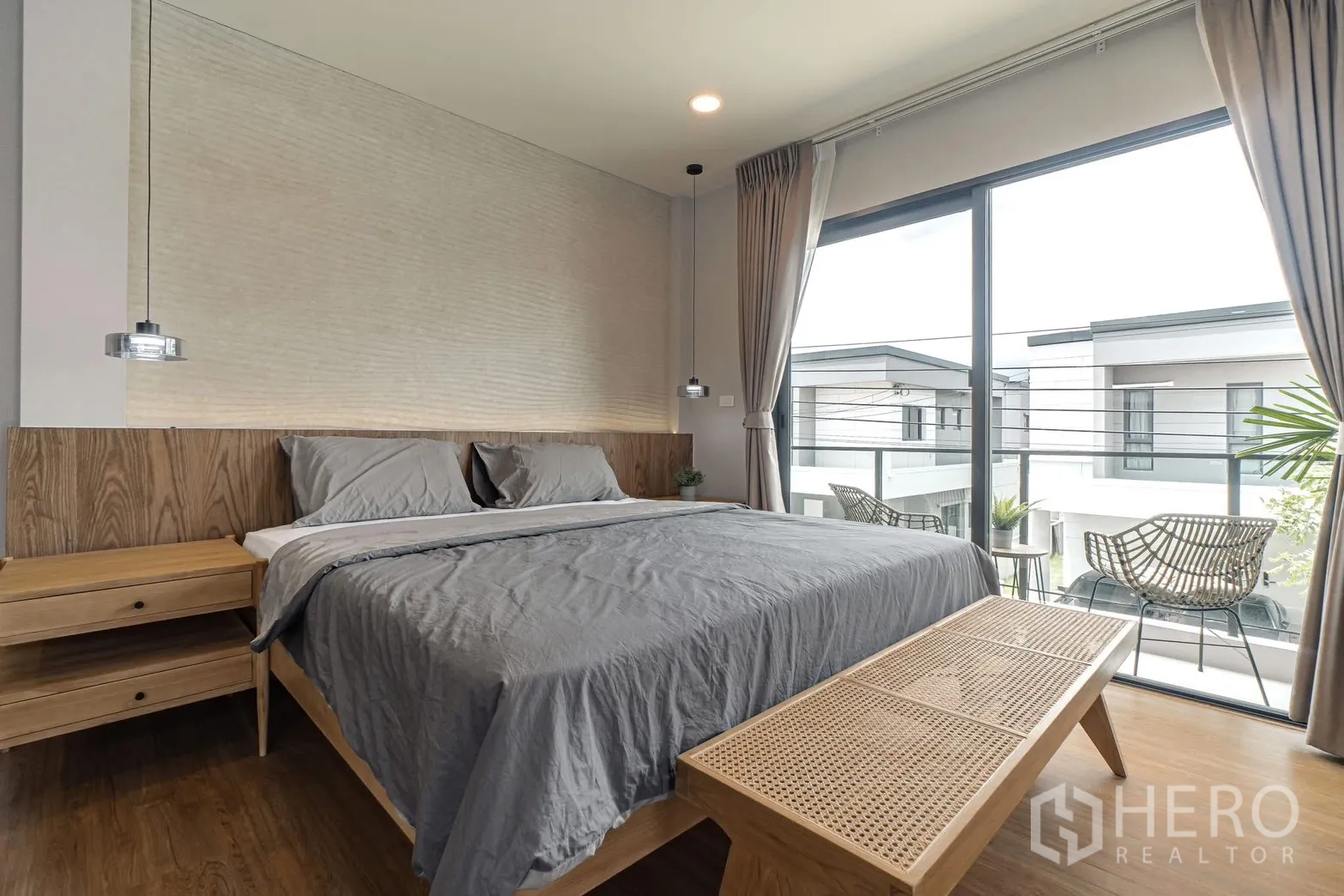 Detached House for rent in Bang Phli, Samut Prakan - Master bedroom with pendant lights, rattan bench, and balcony view.