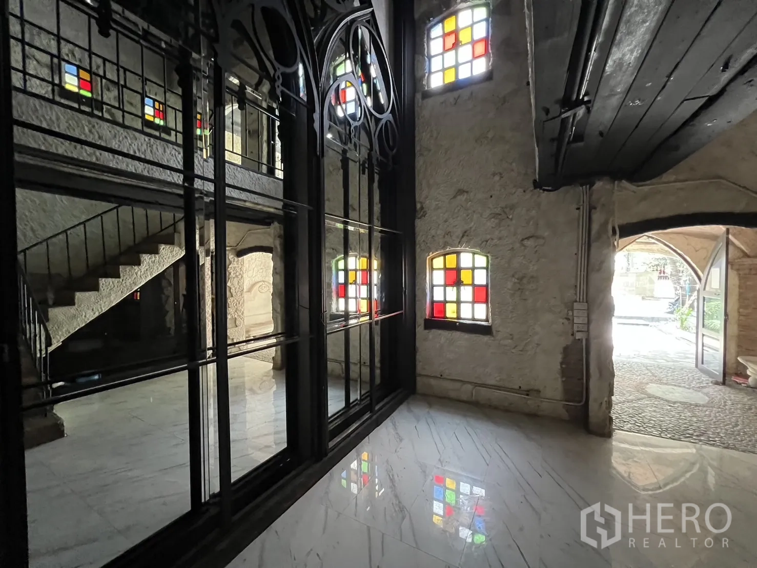 零售空间 出租在Watthana, Bangkok - 一层门厅，黑色金属框大玻璃、楼梯与大理石地面。