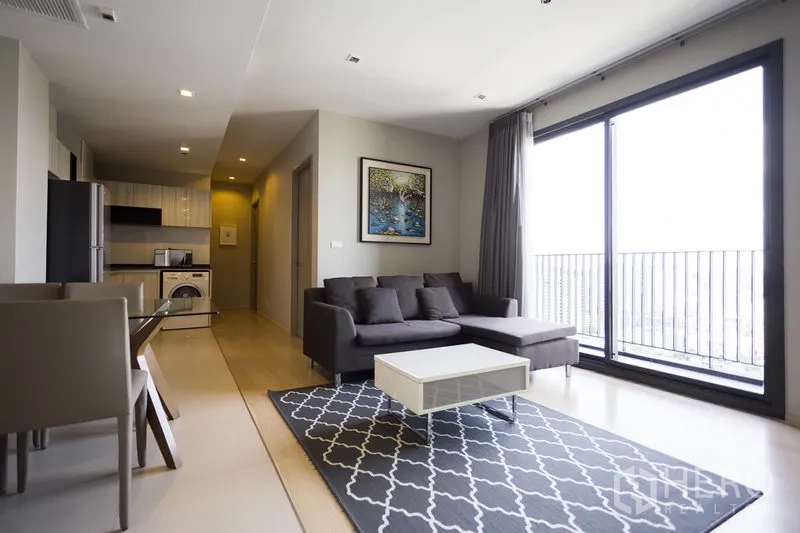 คอนโด ให้เช่าในWatthana, Bangkok - ห้องนั่งเล่นโปร่งสว่าง โซฟา L รูป พรมลาย ประตูกระจกบานใหญ่และครัวพร้อมเครื่องซักผ้า