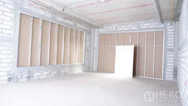 พื้นที่ขายปลีก ให้เช่าในKhlong Toei, Bangkok - มุมมองภายในห้องเปล่าพร้อมช่องหน้าต่างกรอบเหล็กและแผ่นยิปซัม.