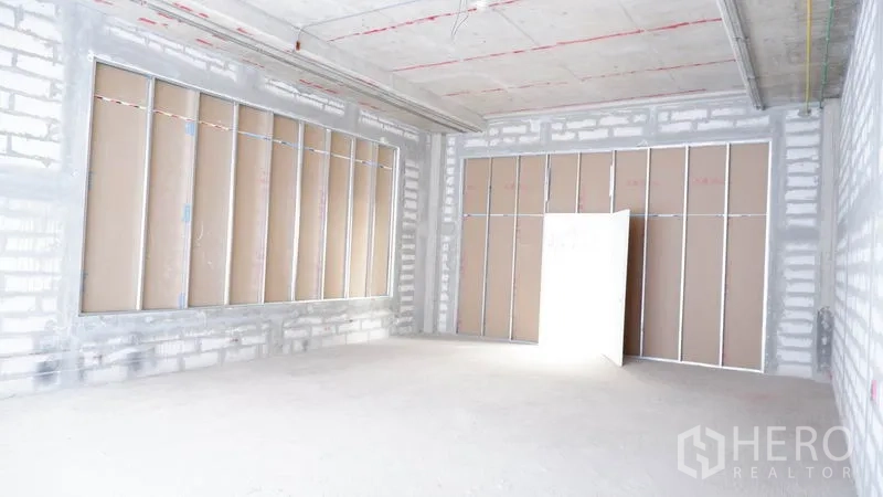 พื้นที่ขายปลีก ให้เช่าในKhlong Toei, Bangkok - มุมมองภายในห้องเปล่าพร้อมช่องหน้าต่างกรอบเหล็กและแผ่นยิปซัม.