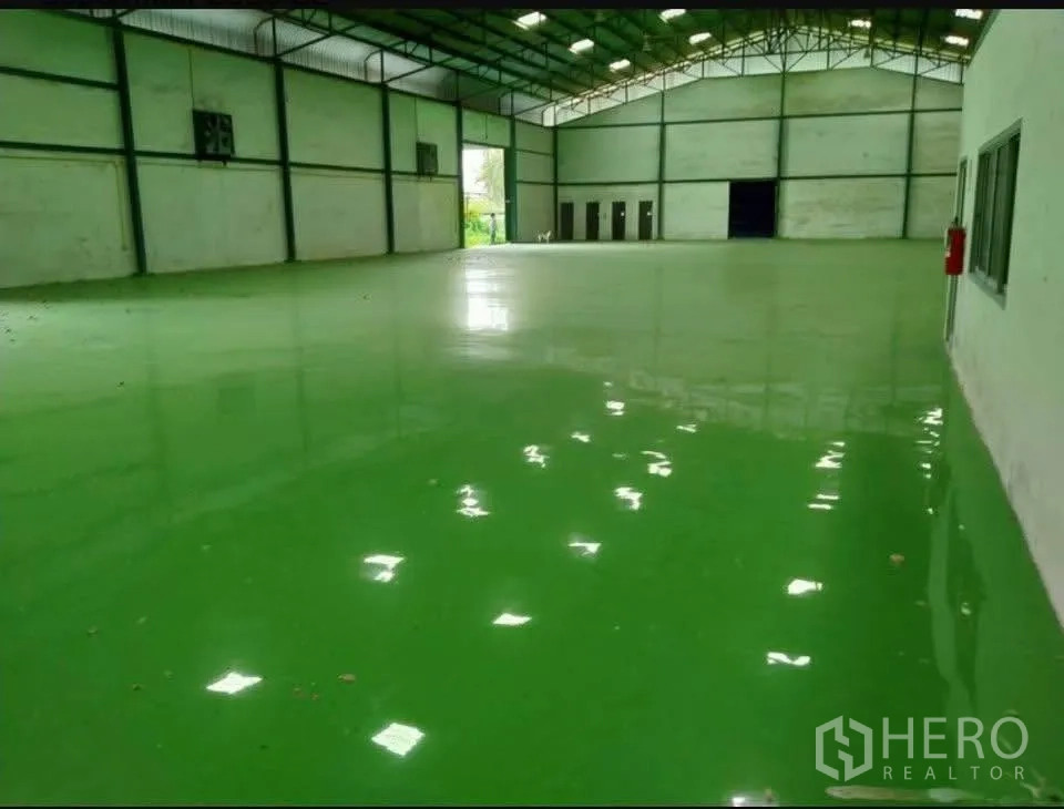 Factory for rent in Bang Phli, Samut Prakan - Expansive hall featuring glossy green epoxy flooring and overhead lighting.