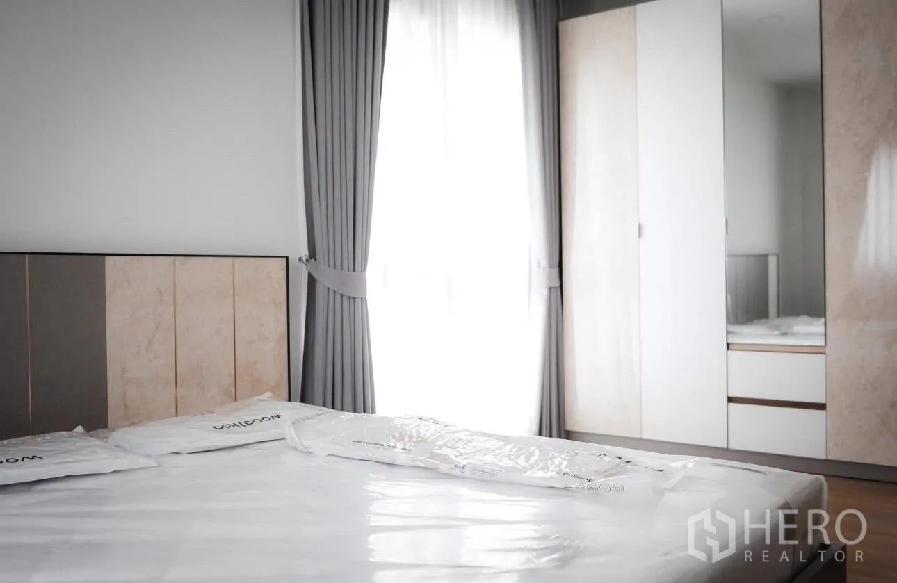 Detached House for rent in Bang Phli, Samut Prakan - Bedroom with upholstered headboard and built-in wardrobe with mirror.