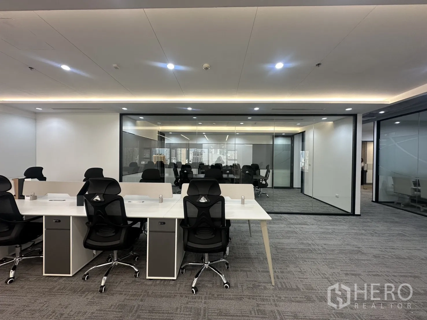 办公室 for rent in Pathum Wan, Bangkok - 开放式办公区，白色工位与黑色人体工学椅，旁为玻璃隔断会议室。