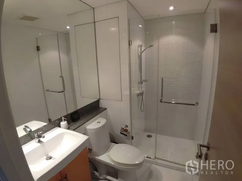 公寓 出租在Watthana, Bangkok - 现代卫浴，玻璃淋浴间、洗手台与座厕。