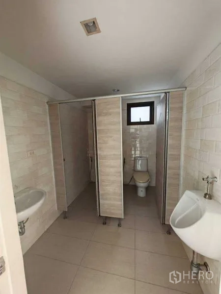 Office Space for rent in Bang Kho Laem, Bangkok - Bathroom with toilet stalls, a urinal and a small window for ventilation.