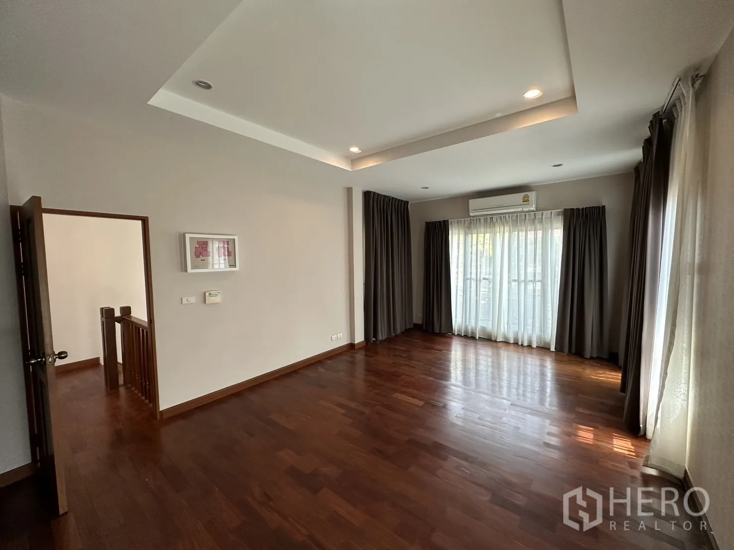 Detached House for rent or sale in Pak Kret, Nonthaburi - Master bedroom with wood flooring, recessed ceiling and large windows.