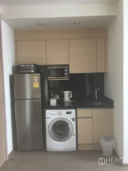 公寓 出租或出售在Khlong Toei, Bangkok - 紧凑厨房，配冰箱、微波炉、洗衣机与黑色台面