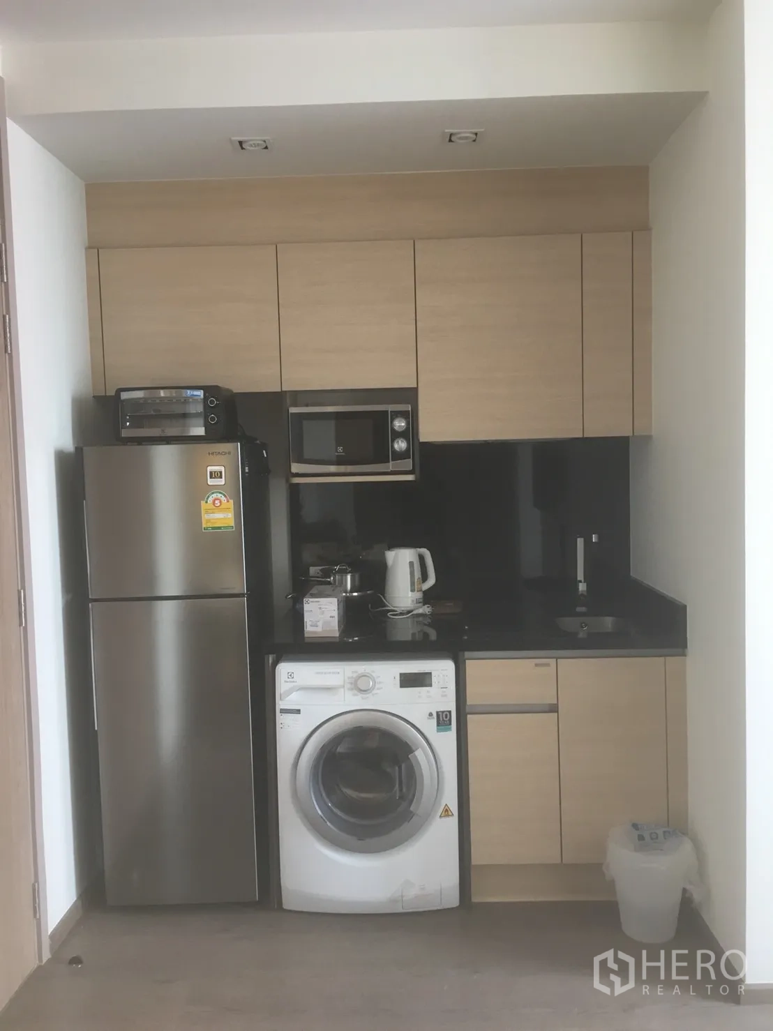 公寓 出租或出售在Khlong Toei, Bangkok - 紧凑厨房，配冰箱、微波炉、洗衣机与黑色台面