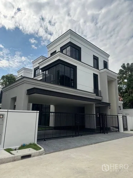 Detached House for rent - Corner view of modern house with gated driveway and expansive glass windows.