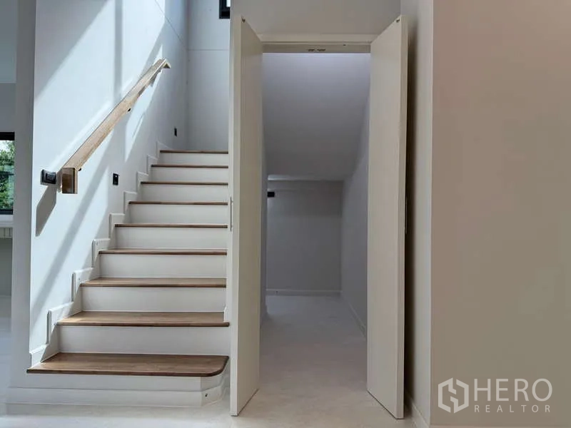 Detached House for rent or sale in Bang Phli, Samut Prakan - Staircase with wooden treads and an under-stair storage room.