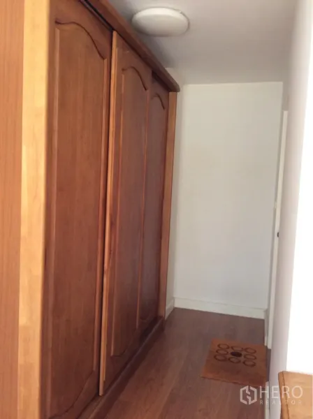 คอนโด ขายในPathum Wan, Bangkok - โถงทางเดินมีตู้เสื้อไม้บิวท์อินขนาดใหญ่และพื้นลามิเนตลายไม้