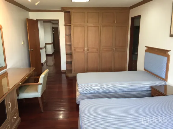 Condominium for rent in Watthana, Bangkok - Bright twin bedroom with desk, ample wardrobes and glossy timber floors.