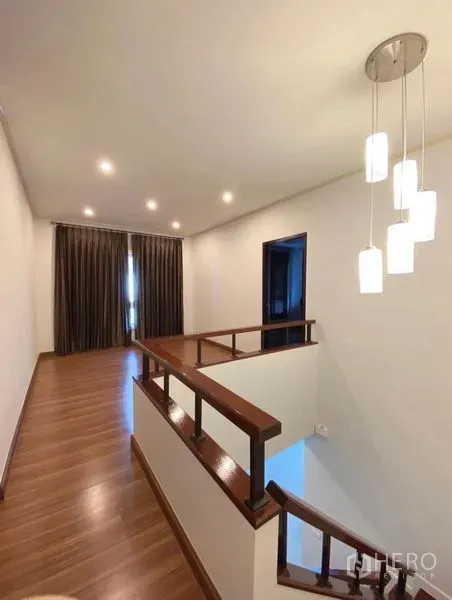 Detached House for sale in Bang Phli, Samut Prakan - Upstairs landing with pendant lights, wooden handrail, and wood-look flooring.