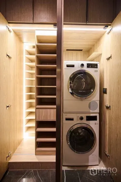 Condominium for rent in Pathum Wan, Bangkok - Built-in utility closet featuring stacked washer and dryer with illuminated shelving.
