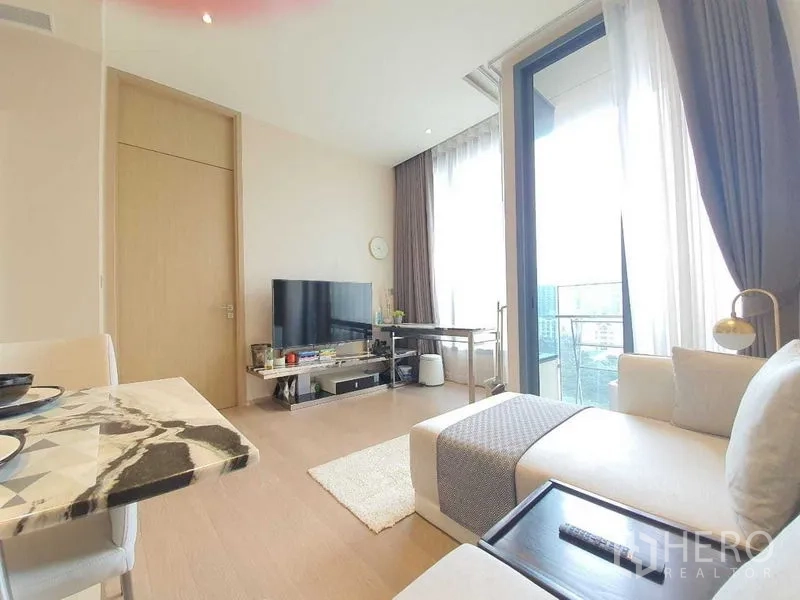 คอนโด ให้เช่าหรือขายในWatthana, Bangkok - ห้องนั่งเล่นพร้อมชั้นวางทีวี โต๊ะกินข้าวหินอ่อน และประตูกระจกสูงออกสู่ระเบียง