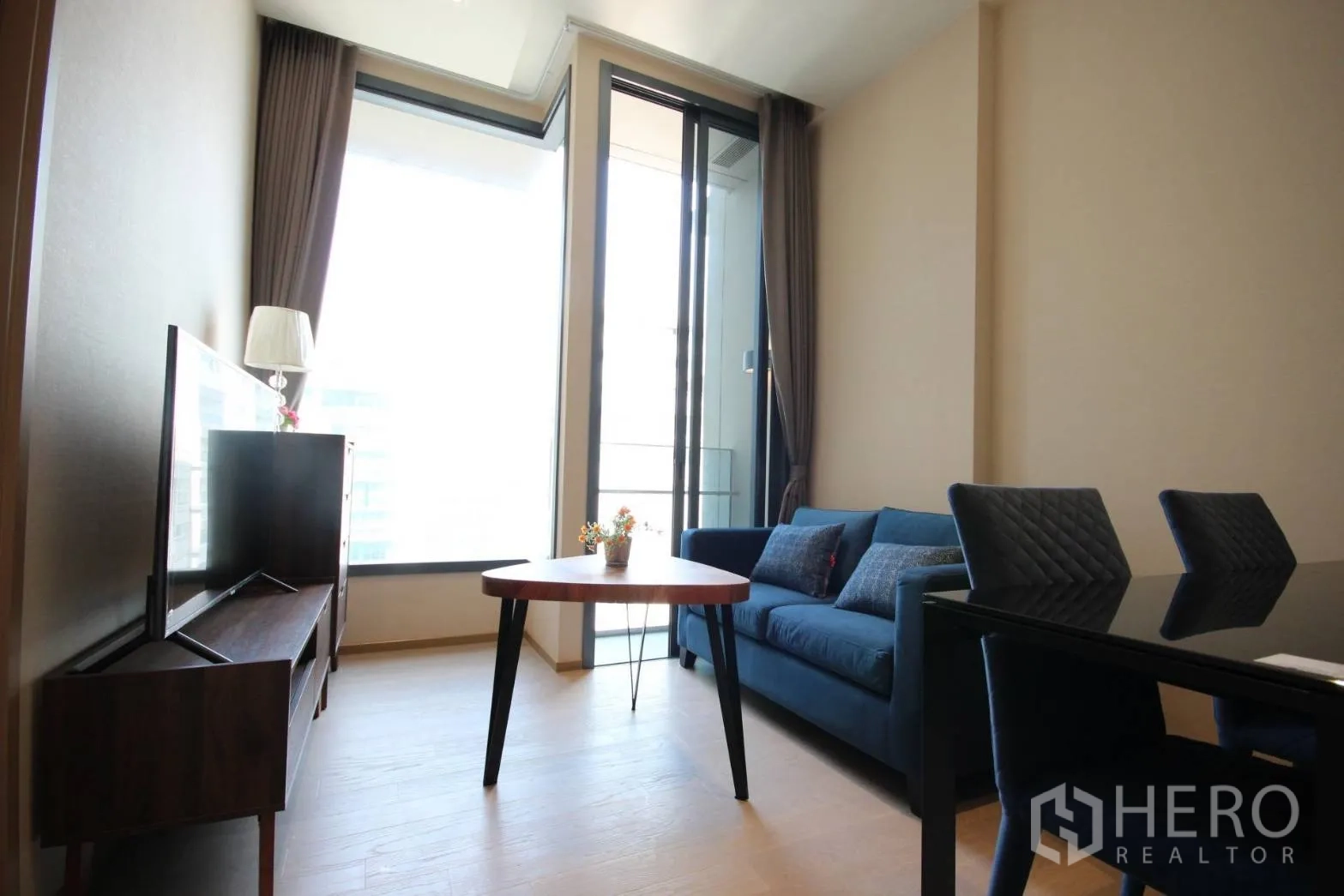 คอนโด ให้เช่าในWatthana, Bangkok - ห้องนั่งเล่นมีหน้าต่างสูงถึงเพดาน ประตูออกระเบียง ชั้นวางทีวี และโซฟา