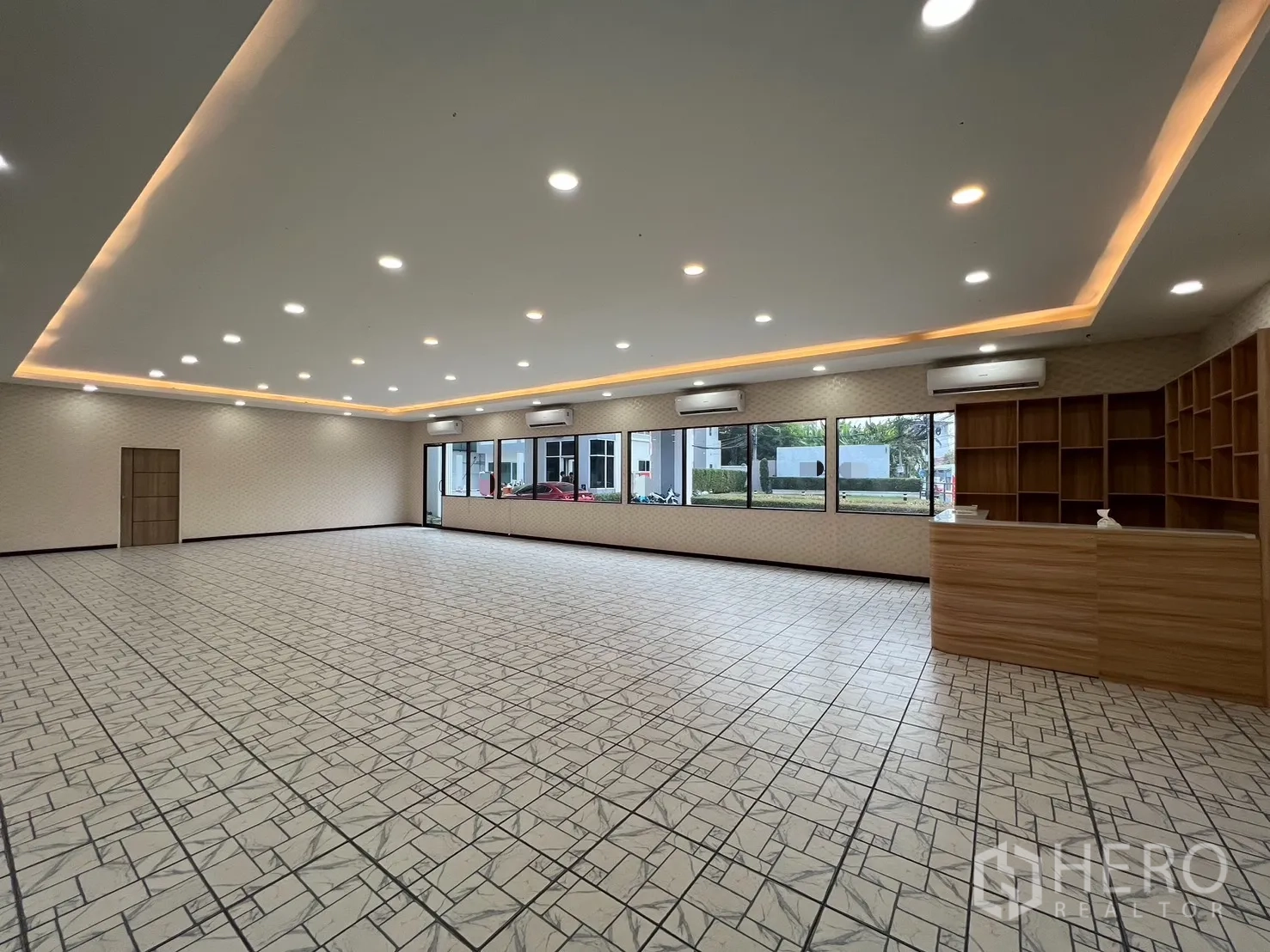 零售空间 for rent in Bueng Kum, Bangkok - 宽敞开放式零售大厅，嵌入式照明、拼花地砖、大窗与木质接待台及货架。