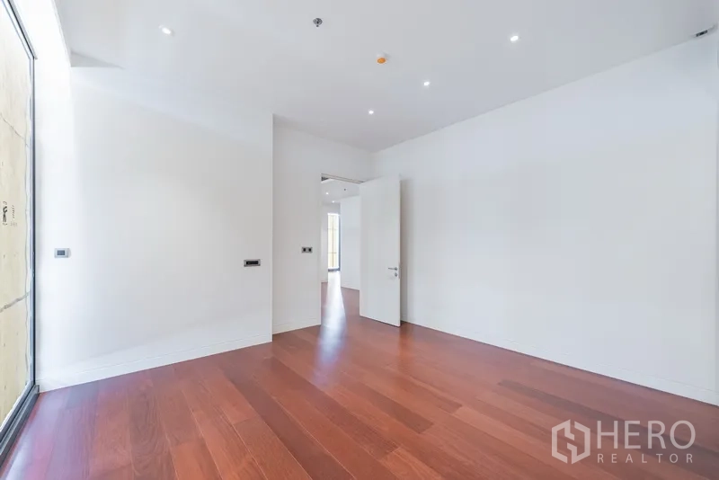 คอนโด ขายในWatthana, Bangkok - ห้องนอนสว่างด้วยแสงธรรมชาติ พื้นไม้ และประตูเปิดสู่โถงทางเดิน