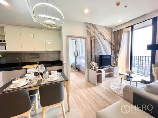 คอนโด ให้เช่าในKhlong Toei, Bangkok - โซนครัว รับประทานอาหาร และนั่งเล่นแบบโอเพ่นแปลน พร้อมโคมไฟสมัยใหม่และทางออกสู่ระเบียง