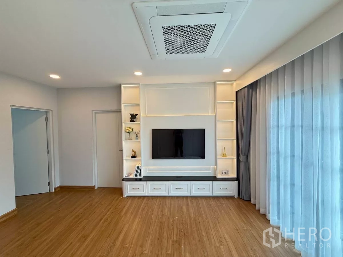 Detached House for rent in Bang Phli, Samut Prakan - Upper lounge with feature TV wall, sliding balcony doors and wood flooring.