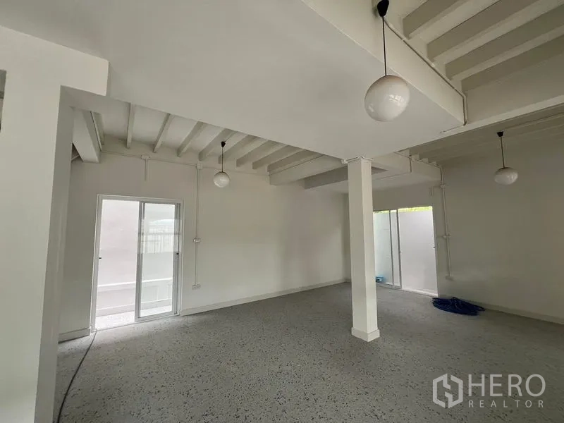 สำนักงานที่บ้าน ให้เช่าในHuai Khwang, Bangkok - พื้นที่นั่งเล่น/ออฟฟิศเปิดโล่ง มีเสา หน้าต่างบานกว้าง และพื้นลายจุดเงา