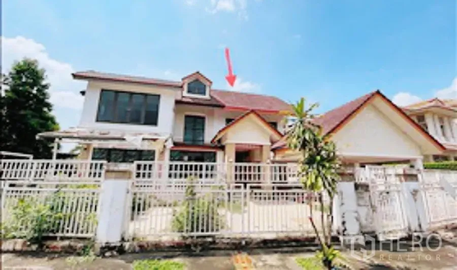 独立式住宅 出售在Khan Na Yao, Bangkok - 两层独栋别墅外观，红色斜屋顶与白色围栏及车道