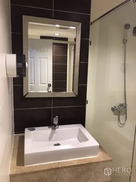 คอนโด ให้เช่าหรือขายในWatthana, Bangkok - ห้องน้ำสมัยใหม่พร้อมตู้กระจกอาบน้ำ อ่างล้างหน้า และกระจกบานใหญ่