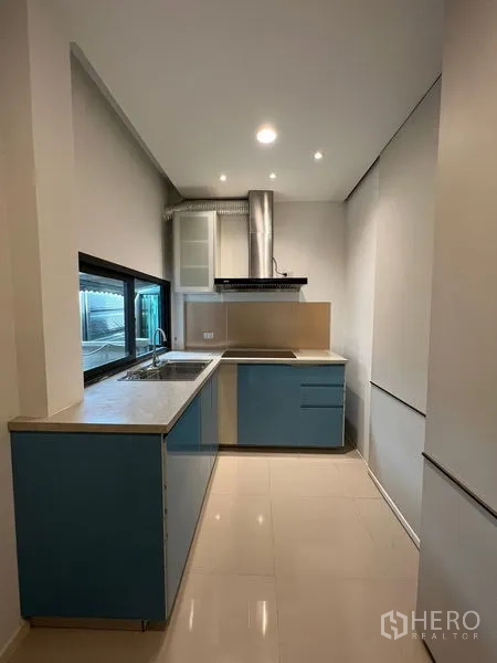 บ้าน ให้เช่าในSaphan Sung, Bangkok - ครัวบิวท์อิน ตู้ล่างสีน้ำเงิน เคาน์เตอร์ อ่างล้างจาน และเครื่องดูดควันสแตนเลส