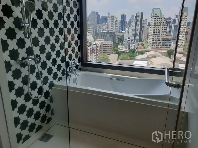 คอนโด ให้เช่าหรือขายในKhlong Toei, Bangkok - ห้องน้ำพร้อมฝักบัวกระจกและอ่างอาบน้ำติดหน้าต่างชมวิวสกายไลน์กรุงเทพฯ.