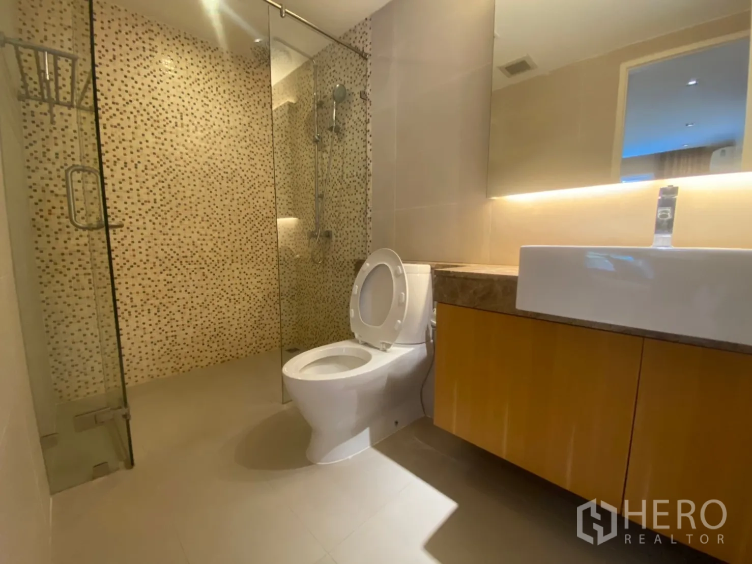 公寓 出租在Watthana, Bangkok - 卫浴配玻璃淋浴间、马赛克墙面与灯带镜柜。