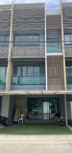 Townhouse for sale in Bueng Kum, Bangkok - Modern three-storey townhouse facade with glass balconies and covered parking in Bangkok.