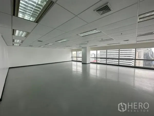 Office Space for rent - Bright office area with white walls, columns and wide city-view windows.