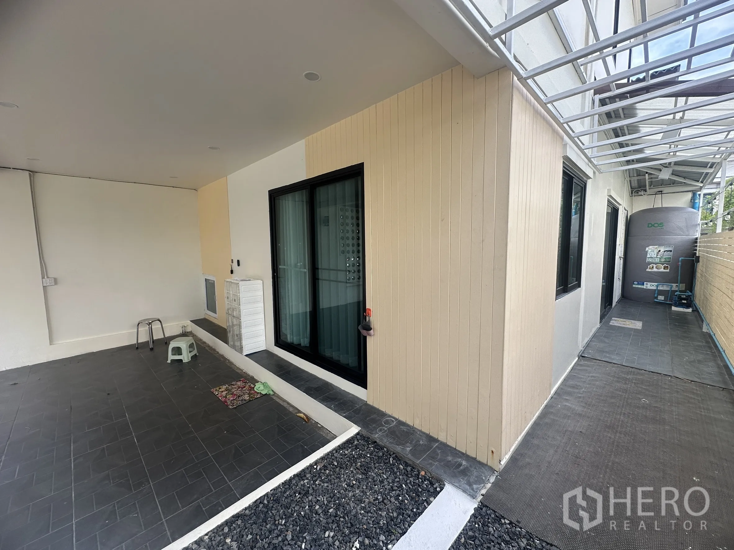 联排别墅 for sale in Lam Luk Ka, Pathum Thani - 侧边步道配有顶棚、私密围栏和储水罐。