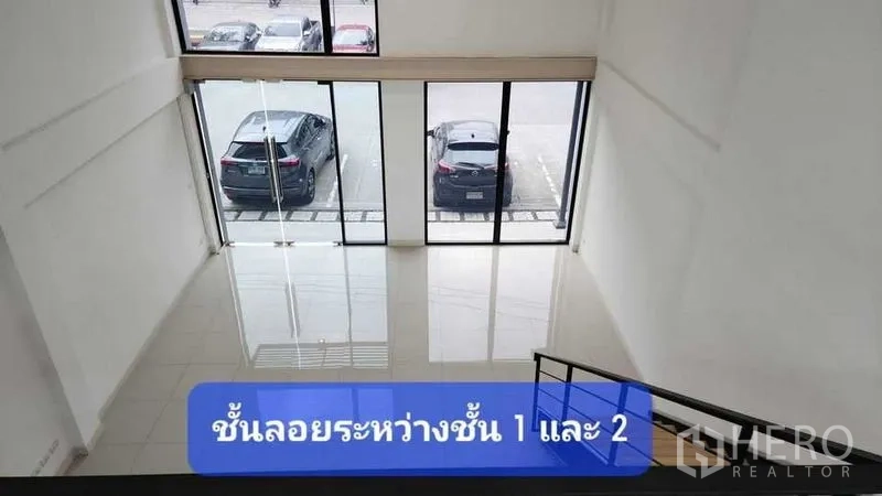 ทาวน์เฮาส์ ให้เช่าในBueng Kum, Bangkok - โถงหน้าบ้านเพดานสูงแบบดับเบิลวอลุ่ม มองเห็นกระจกเต็มบานและที่จอดรถจากชั้นลอย