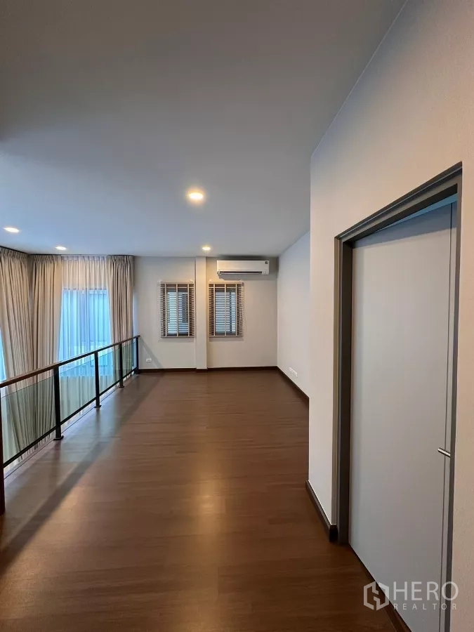 Detached House for rent in Bang Phli, Samut Prakan - Upper floor hallway with wood flooring, windows, and air conditioner.