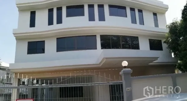 Home Office for rent in Watthana, Bangkok - Three-storey white home office exterior with curved windows and gated fence in Thonglor.