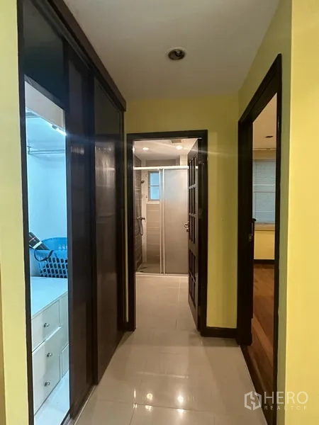 Condominium for sale in Watthana, Bangkok - Hallway with built-in wardrobes leading to the bathroom and bedroom.