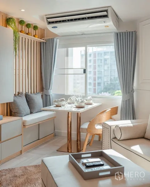 Condominium for sale in Yan Nawa, Bangkok - Cozy dining corner with built-in bench seating, air conditioner, and city-view window.