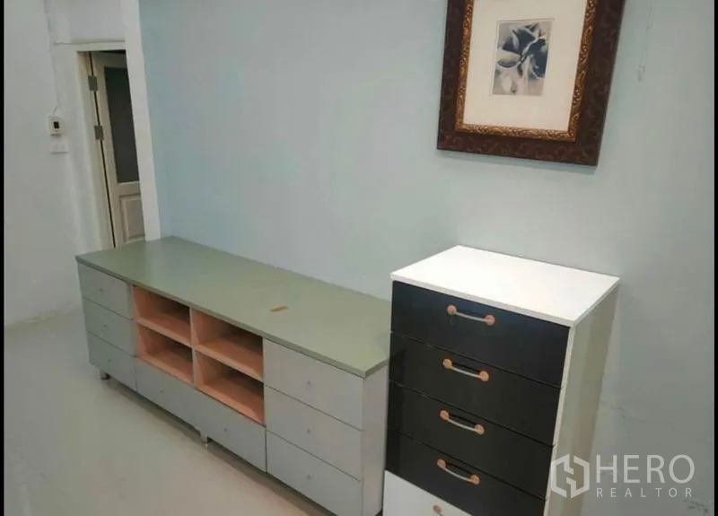 Detached House for rent in Wang Thonglang, Bangkok - Low TV console and drawer unit against a pale wall with framed artwork.