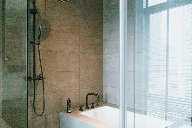 Condominium for rent in Watthana, Bangkok - Tiled bathroom with bathtub, glass shower screen, and rainfall shower.
