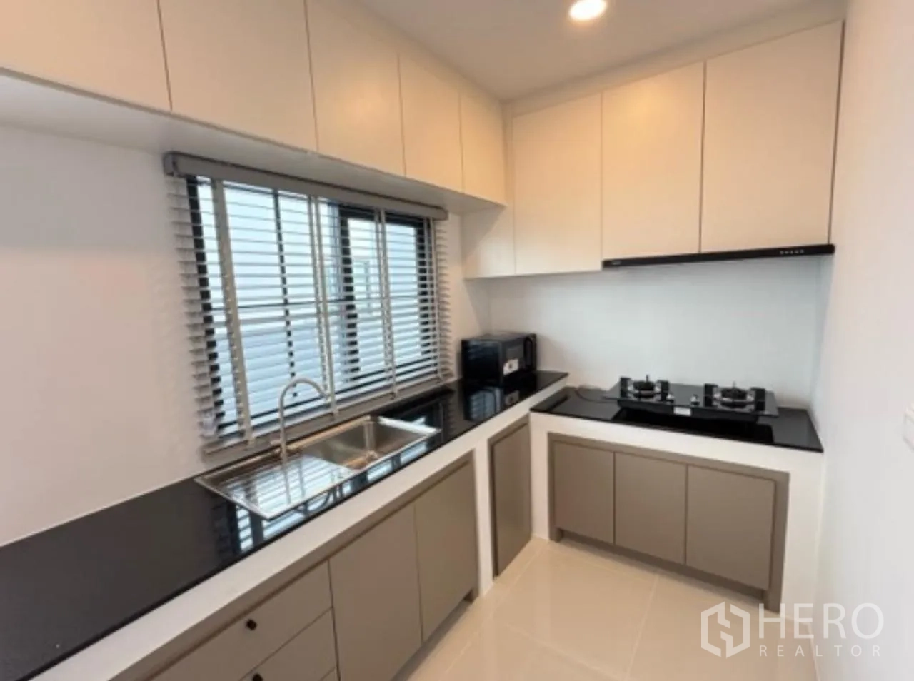 独栋房屋 for rent in Bang Phli, Samut Prakan - 封闭式现代厨房，L形操作台，双槽水槽、燃气灶与柜体。