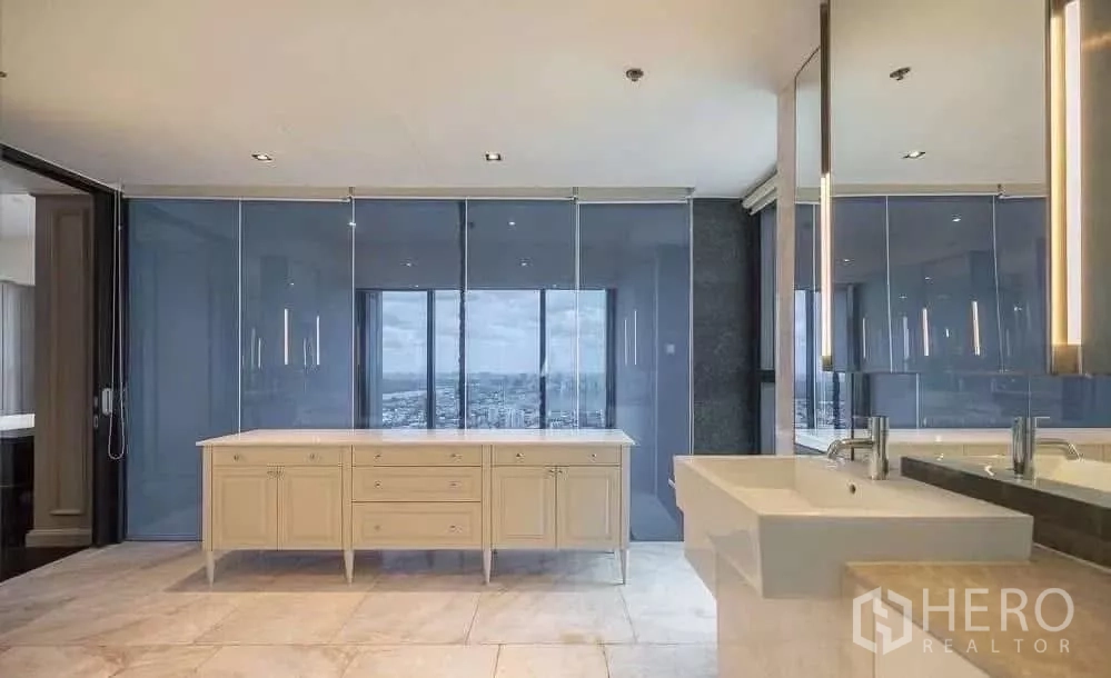 Condominium for rent in Sathon, Bangkok - Large bathroom with wide vanity, mirrors and glass wall facing Bangkok views.