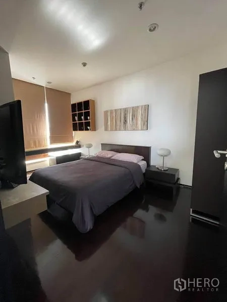 Condominium for rent or sale in Watthana, Bangkok - Alternate view of master bedroom with bedside tables, built-in storage and blinds.