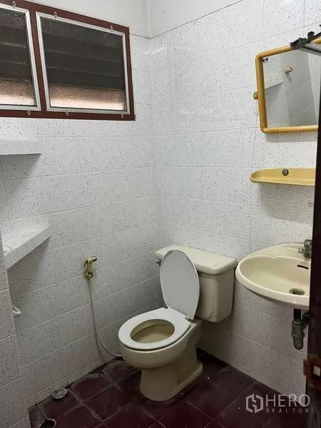 Factory for rent in Bang Na, Bangkok - Basic restroom with toilet, sink, mirror and louvered windows.