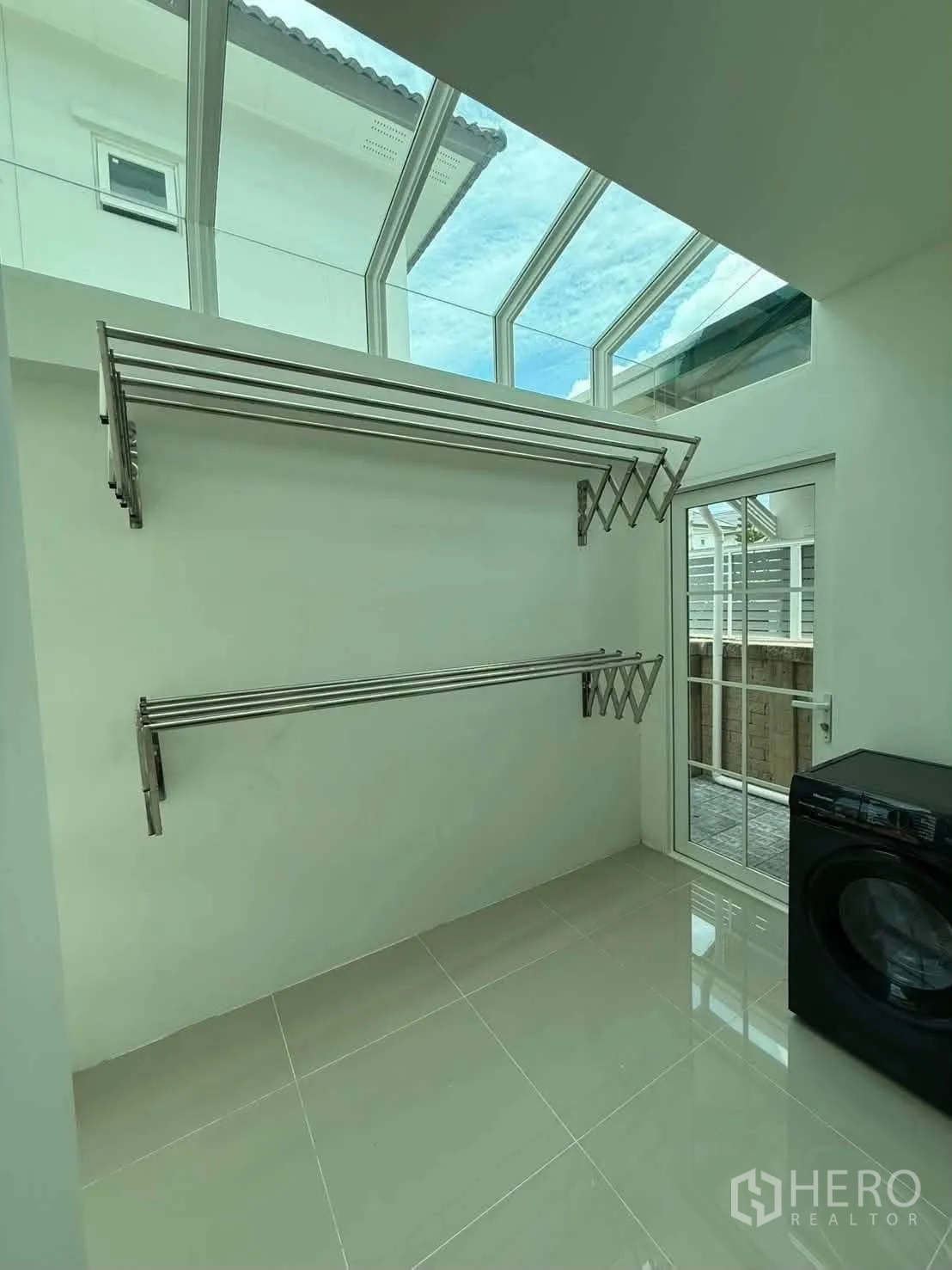 Detached House for rent in Bang Phli, Samut Prakan - Laundry room with skylight roof, wall-mounted drying racks, and washing machine.