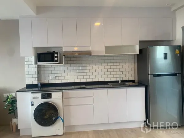 联排别墅 出租 - 现代直线型厨房，白色柜体、地铁砖墙面、洗衣机与不锈钢冰箱。