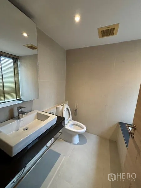 คอนโด ให้เช่าในWatthana, Bangkok - ห้องน้ำพร้อมกระจกบานใหญ่ อ่างล้างหน้าทรงสี่เหลี่ยม โถสุขภัณฑ์ และหน้าต่างมีมู่ลี่ข้างอ่างอาบน้ำ