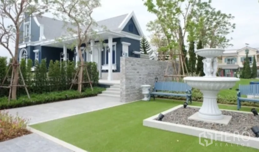 Townhouse for rent in Bang Phli, Samut Prakan - Clubhouse lawn with classic fountain and manicured greenery.